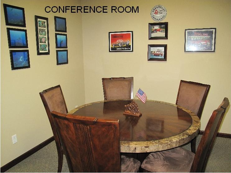 A conference room with four chairs and a table.