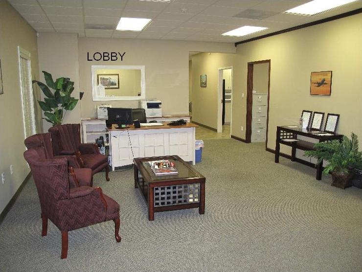 A room with chairs, tables and a desk.
